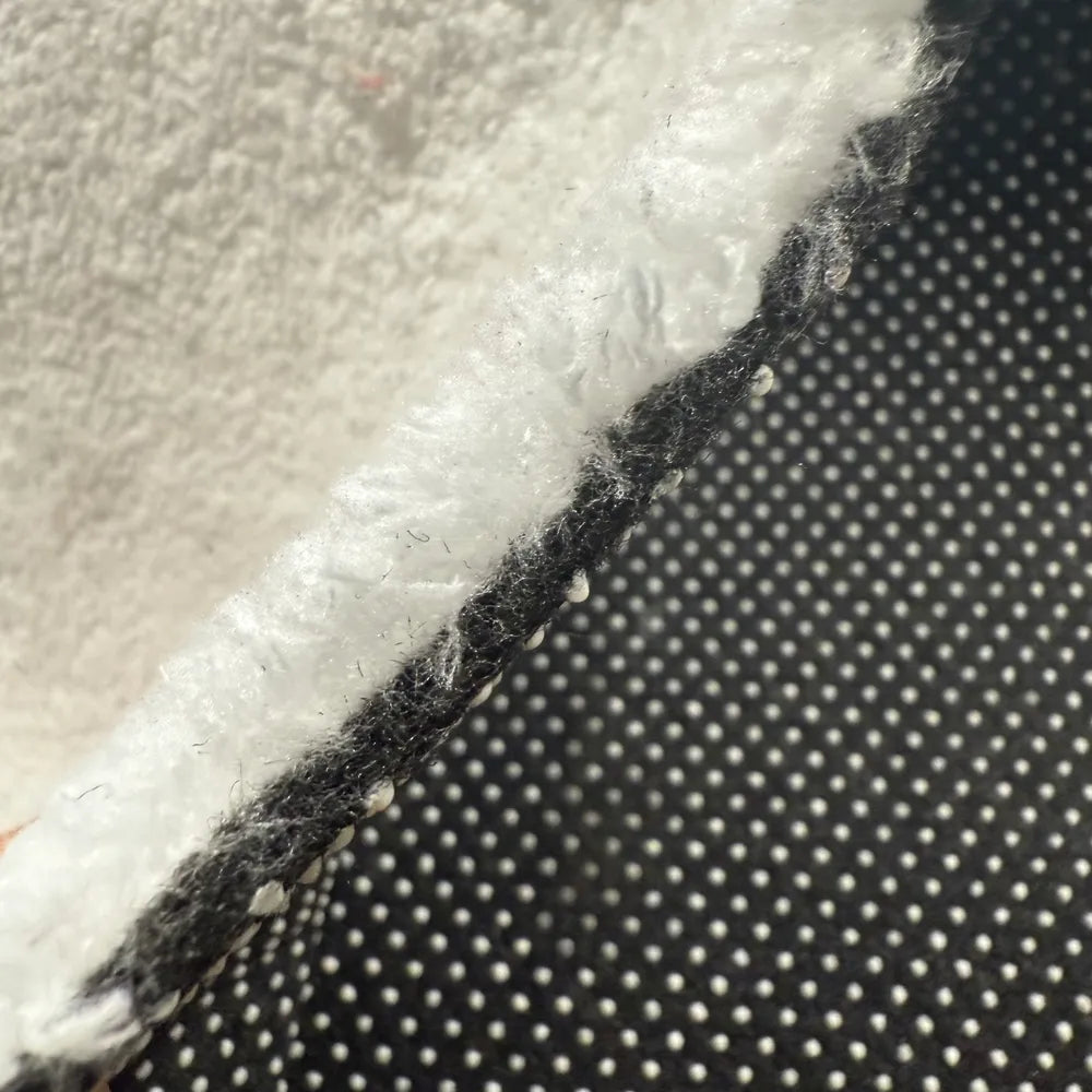 Cross-section detail of faux cashmere rug showing pile, middle layer and non-slip backing.