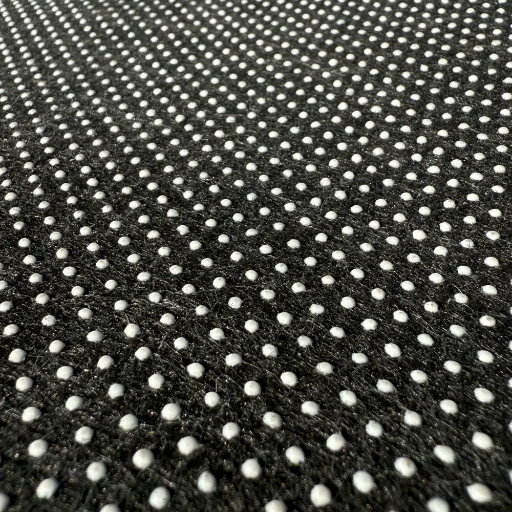 Close-up of the non-slip dotted backing on the 5ft round abstract wave faux cashmere rug from A Print Nest