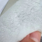 Detailed close-up of the soft white faux silk rug surface and fine fibers