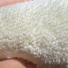 Close-up of a fluffy white fabric held between fingers