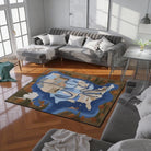A Distance Kept map-inspired rug placed on a living room floor beneath a sectional sofa in natural light