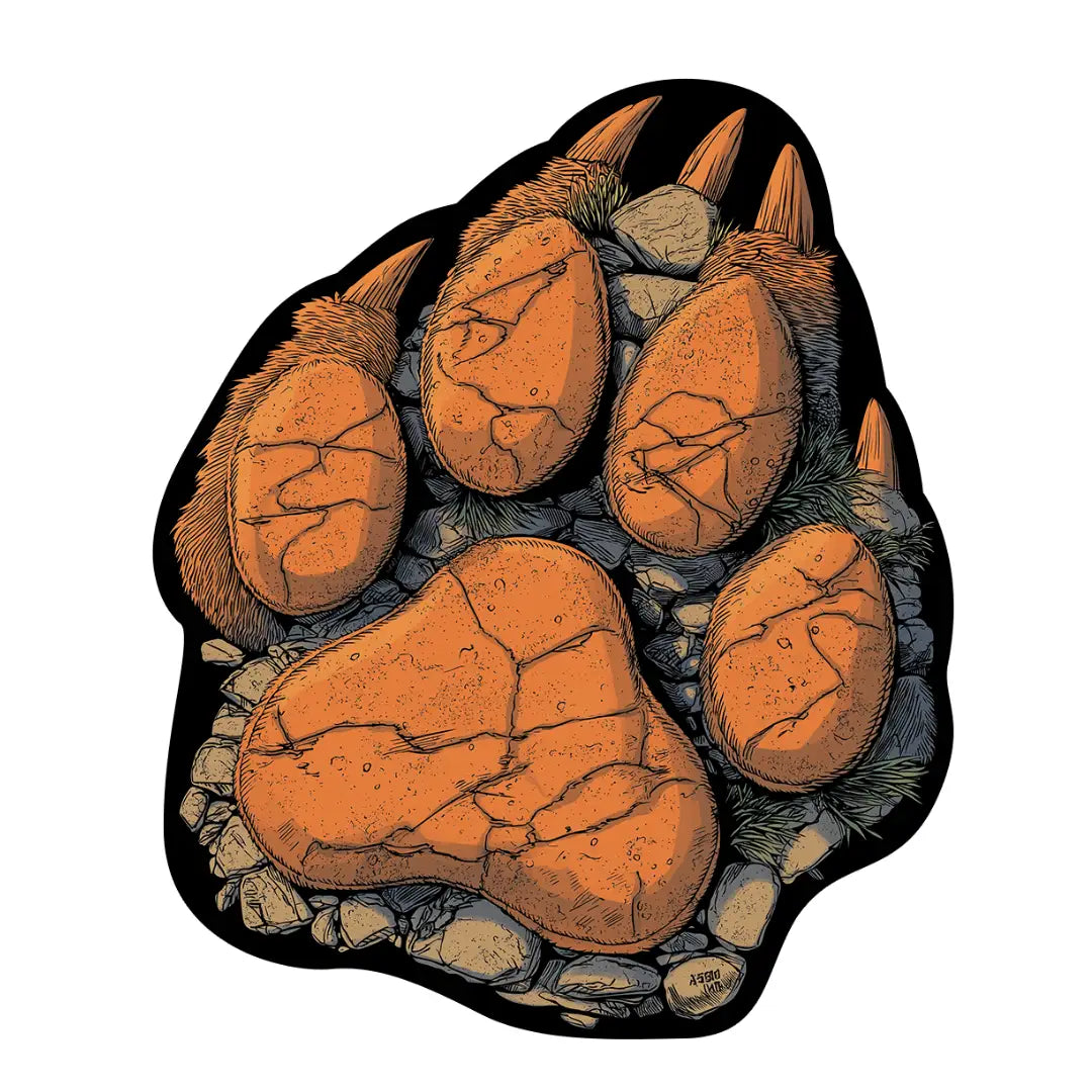 Bear claw shaped rug featuring bold paw print design in earthy orange, charcoal, and stone textures
