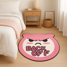 Irregular black “BACK OFF” phrase rug styled beside a bed in a cozy neutral bedroom, showing the faux-cashmere texture and small accent rug size for teen girl room decor.