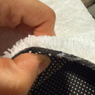 Cross-section detail of faux cashmere rug showing pile, middle layer and non-slip backing.