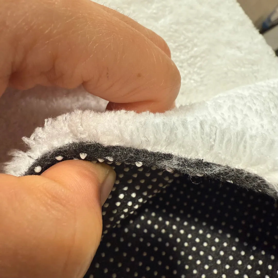 Detailed view of rug’s non-slip backing with raised grip dots designed to keep the rug securely in place.