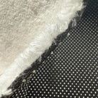 Cross-section detail of faux cashmere rug showing pile, middle layer and non-slip backing.