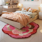 Irregular pink floral rug placed in a cozy bedroom with soft lighting, pastel bedding, and warm decor